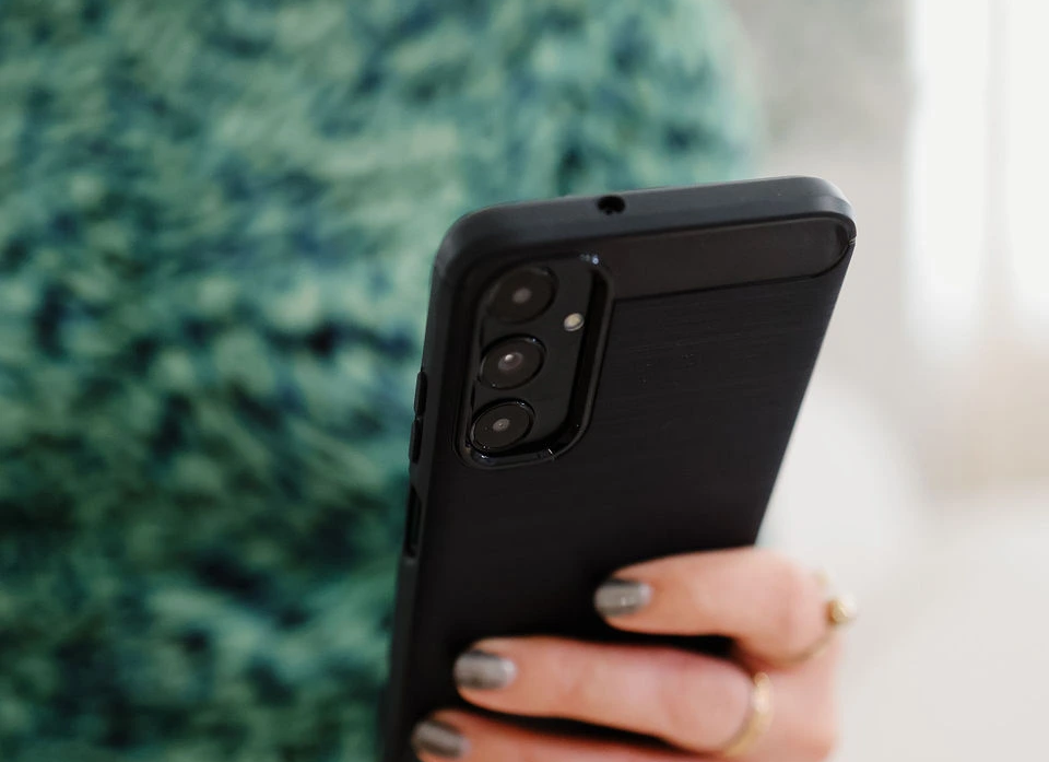 Caroline Burnell, Counsellor, holding a mobile phone.
