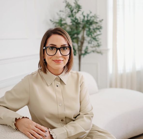 Caroline Burnell, Counsellor, sitting on a sofa and looking at the camera, gently smiling.